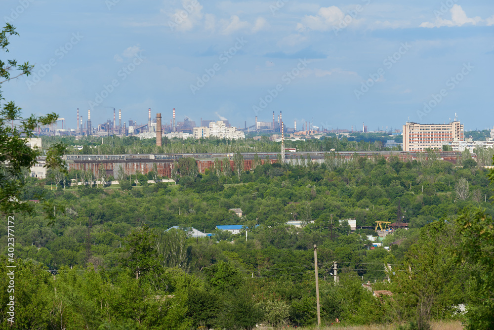 Industrial city behind green spaces, trees, nature Industrial city behind green spaces, trees, nature