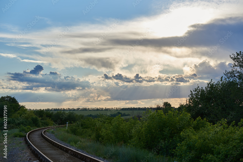 Sunbeams from the clouds shine on the railway