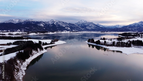 Luftaufnahme mit einer Drohne vom Forggensee im Allgäu im Winter in der blauen Stunde