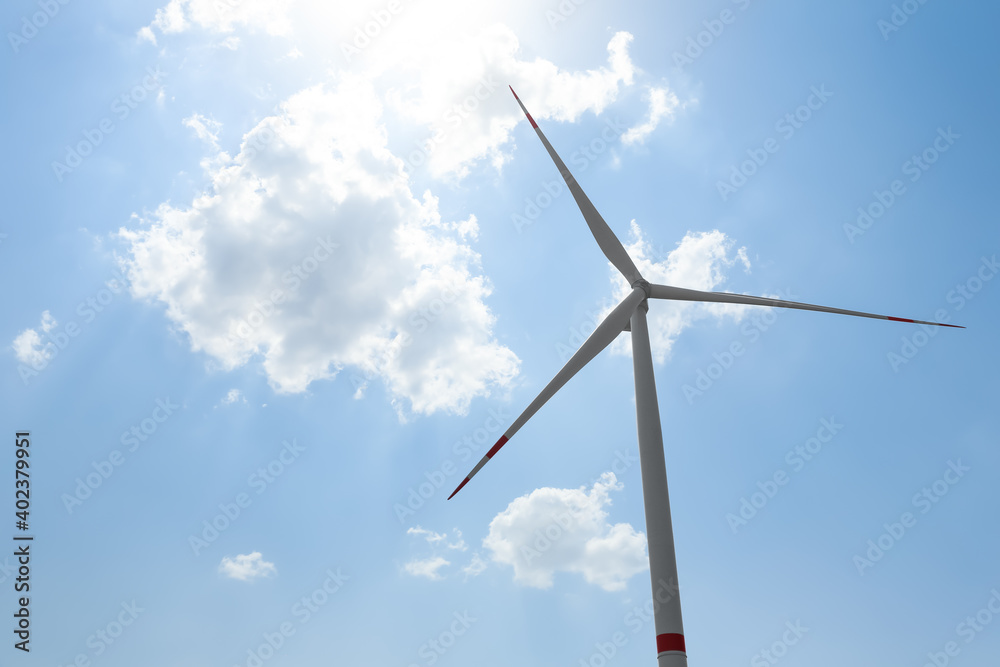 Modern wind turbine against blue sky, low angle view. Energy efficiency Modern wind turbine against blue sky, low angle view. Energy efficiency