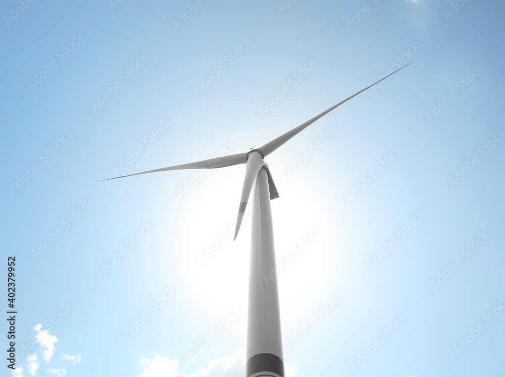 Modern wind turbine against blue sky, low angle view. Energy efficiency Modern wind turbine against blue sky, low angle view. Energy efficiency