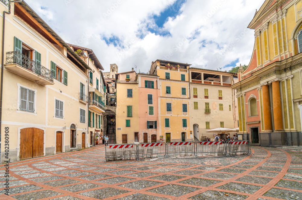 Fototapeta premium View of the narrow entrance and ancient castle fort of the medieval walled hilltop town of Dolceacqua behind the piazza of Sant Antonio Abate Church