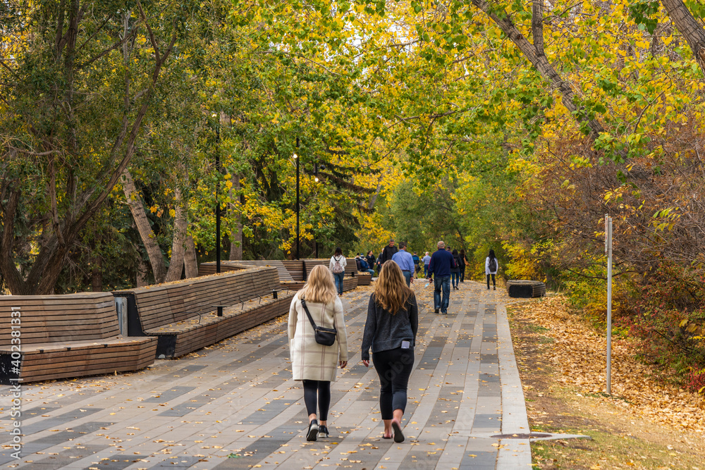Fototapeta premium Citizens relax in the Prince's Island Park in autumn. Downtown Calgary. Calgary, AB, Canada.