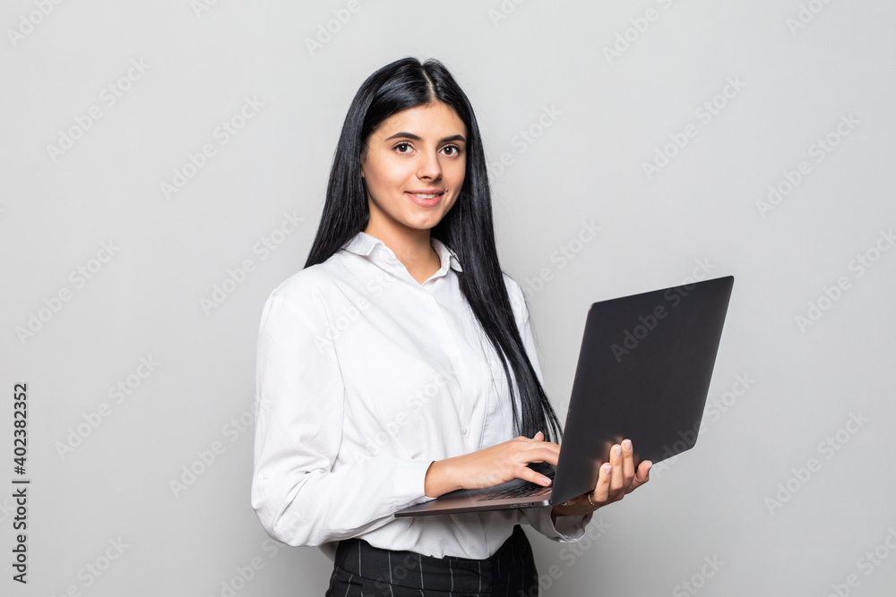 Successful business woman is standing with laptop on white background. Successful business woman is standing with laptop on white background.