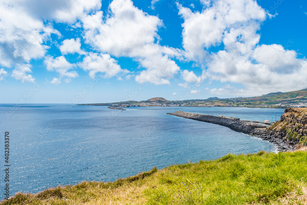 Landscape with stone wall in Praia da Vitória bay with mountain in the background, Terceira - Azores PORTUGAL