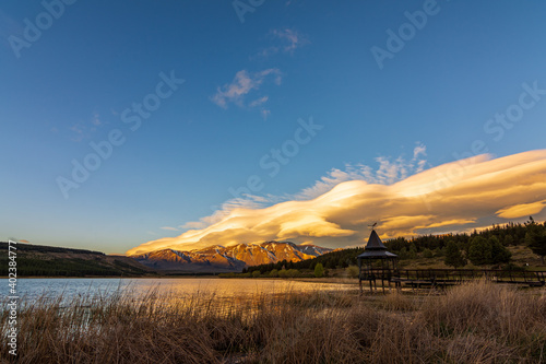 Colorful lenticular clouds over the lake during sunset in Esquel, Patagonia, Argentina
