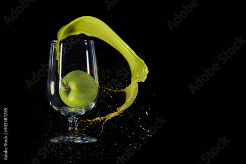 Splash n a glass of green apple or yogurt isolated on black background.