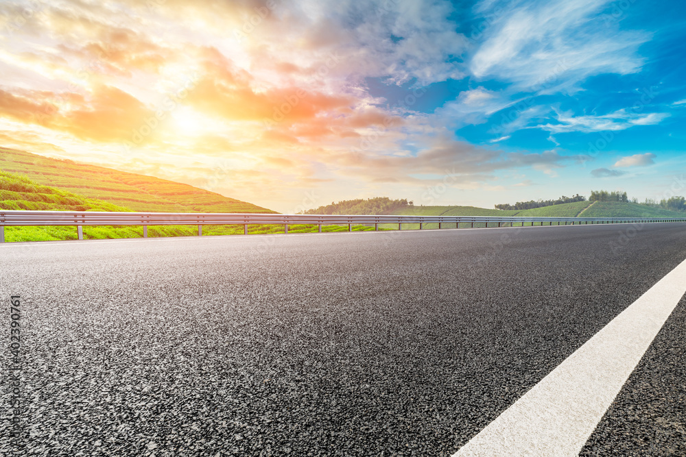 Naklejka premium Asphalt road and mountain with tea plantation at sunset.Road and mountain background.
