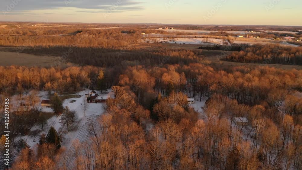 Establishing shot of Midwestern countryside in spring winter season. Aerial view of residential house, outbuildings in the forest. Sunny, soft sunlight at sunset Establishing shot of Midwestern countryside in spring winter season. Aerial view of residential house, outbuildings in the forest. Sunny, soft sunlight at sunset