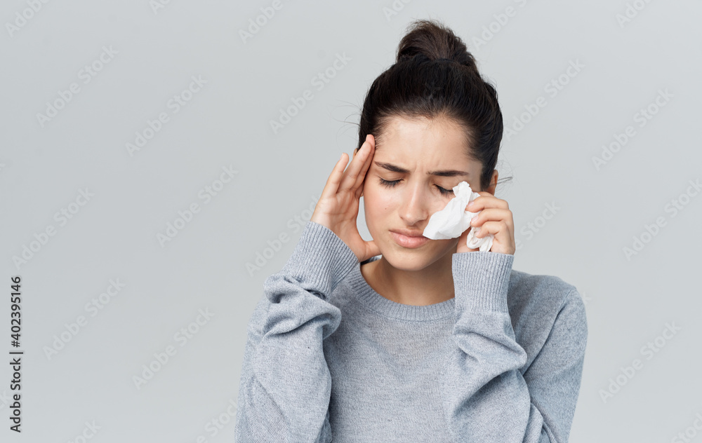 Health problems young woman with napkin runny nose disease gray background Health problems young woman with napkin runny nose disease gray background