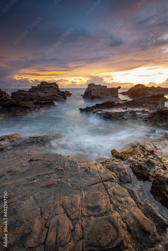 Beach sunset with rock foreground at Sawarna Beach no people
