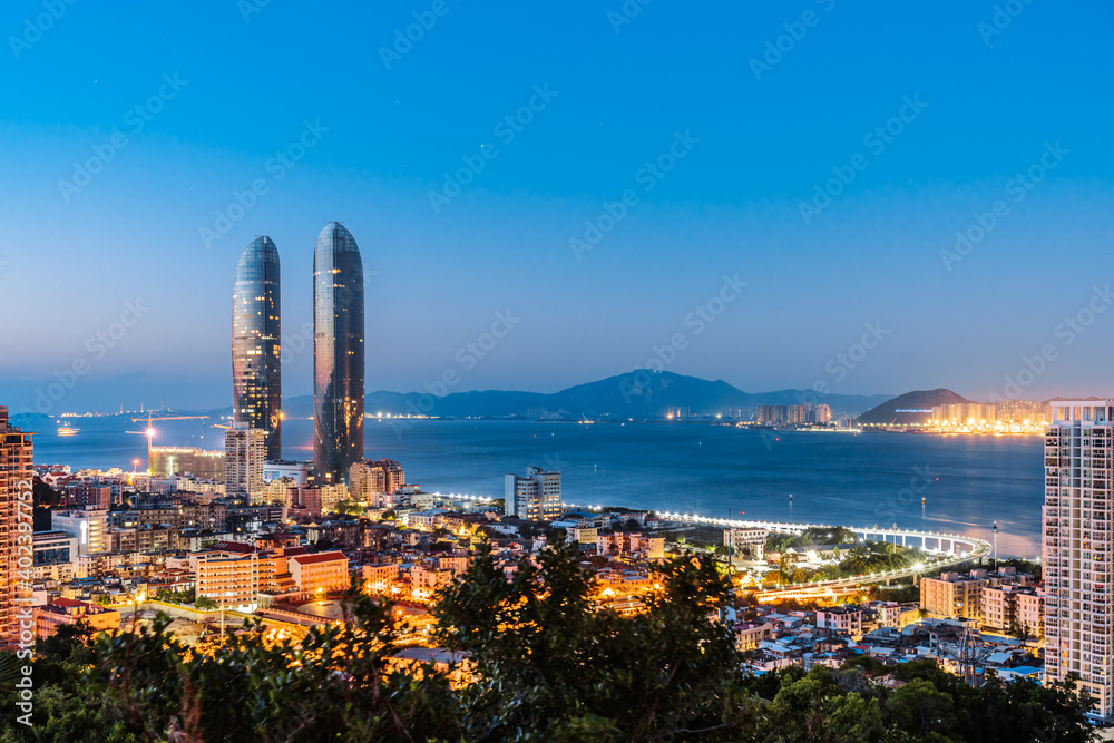 Fototapeta premium Night coastline scenery of twin towers and Yanwu bridge in Xiamen, Fujian, China