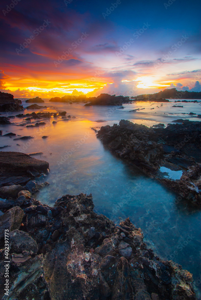 Beach sunset with rock foreground at Sawarna Beach no people