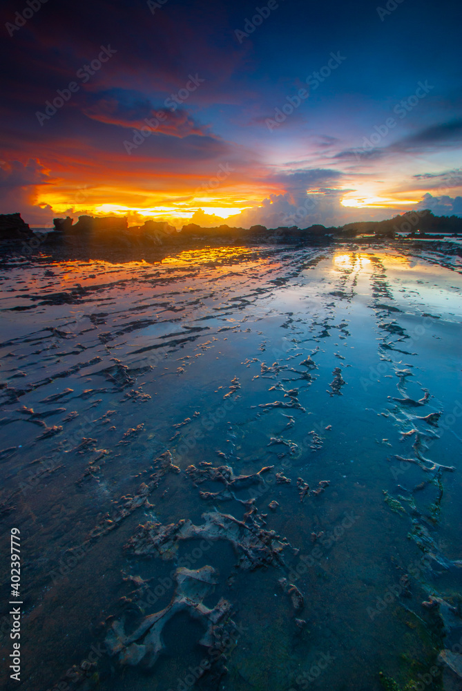 Beach sunset with rock foreground at Sawarna Beach no people