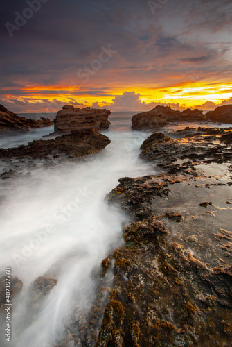Beach sunset with rock foreground at Sawarna Beach no people