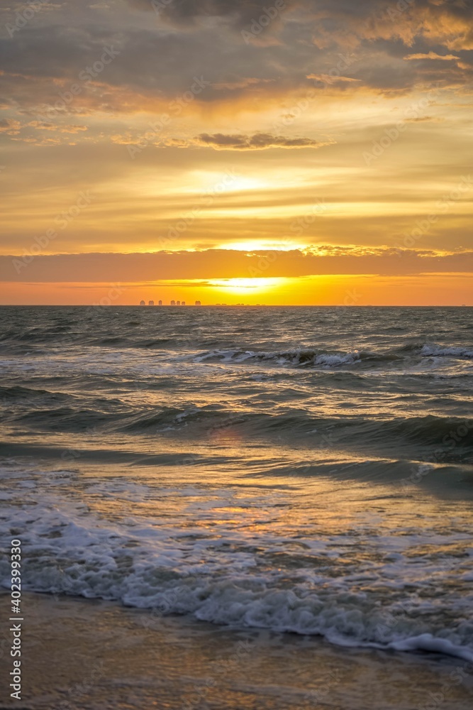 Brilliant orange sunrise over ocean waves along the beach on Sanibel Island, Florida