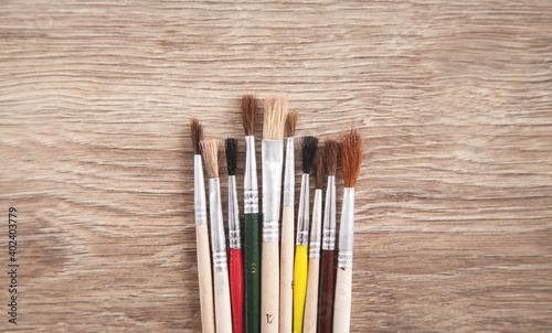 Art brushes on wooden background.
