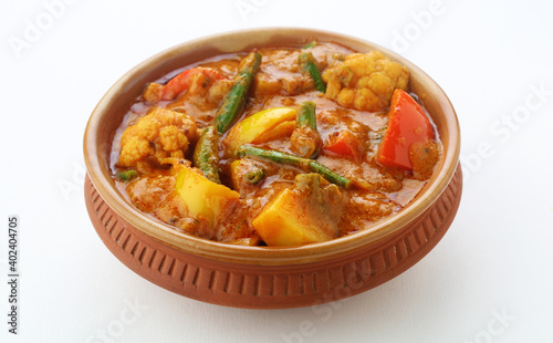 MIX VEGETABLE CURRY- indian recipe, mixed veg , Carrots, cauliflower, green peas and beans with traditional masala red hot and spicy served in a ceramic bowl