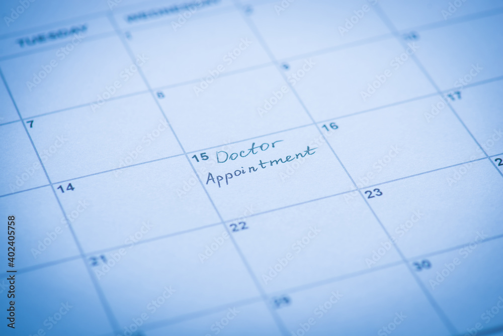 Doctor appointment reminder concept. Cropped close up view photo of calendar cell and hand written words Doctor appointment reminder concept. Cropped close up view photo of calendar cell and hand written words