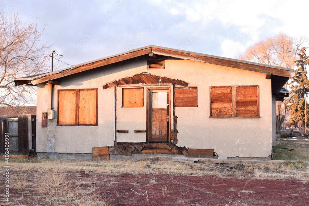 Boarded up stucco house