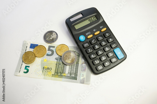 Euro money with coins and a five euro bill, a calculator and a red pencil on a white background, 9,60 minimum wage in germany on July 1, 2021 