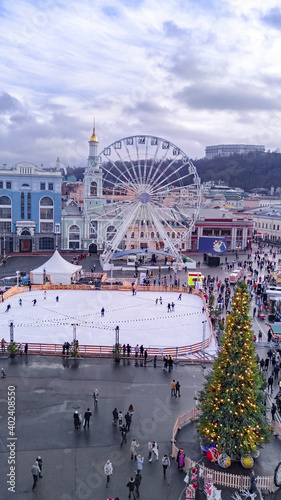 Aerial view of Christmas market Kyiv, Ukraine. Ferris wheel, ice rink, Christmas tree and decoration at Kontraktova square on Podil
