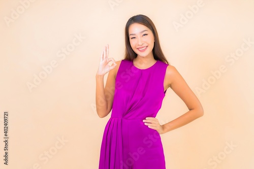 Portrait beautiful young asian woman in action on color background