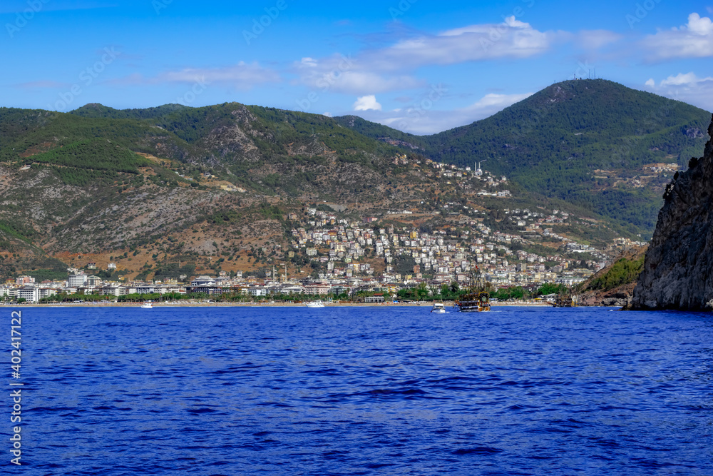 View from the Mediterranean Sea to the coast with the town of Alanya among the mountains (Turkey). Beautiful seascape