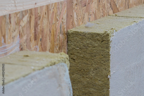 Visible rockwool or thermal insulation of a wooden house. Cut away profile of a wooden panel house insulation.