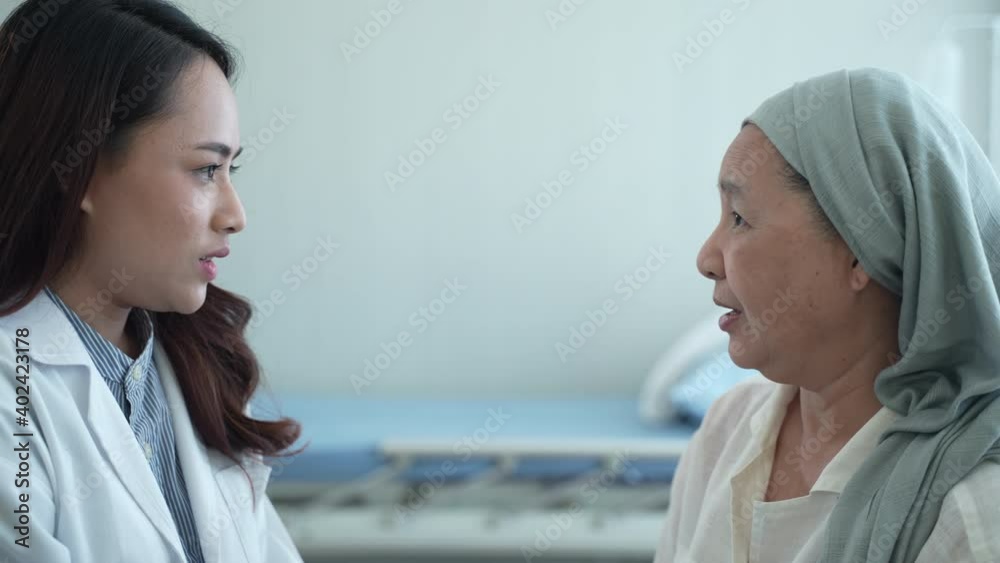 The young professional doctor is examining, treating, and giving instructive advice on health. With elderly female cancer patients, talking together The young professional doctor is examining, treating, and giving instructive advice on health. With elderly female cancer patients, talking together