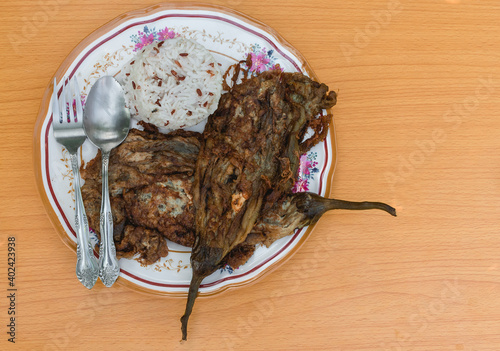 Tortang talong, also known as eggplant omelette, is a Filipino dish. Served with a cup of rice. photo