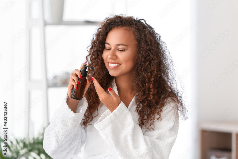 Beautiful young woman with cosmetic oil at home Beautiful young woman with cosmetic oil at home