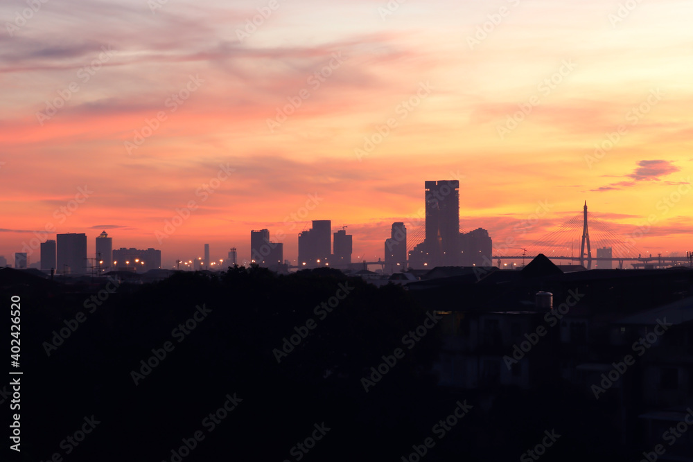 Orange morning sky sunrise over city skyscraper view, skyline horizon cityscape and urban architecture  buildings at dawn