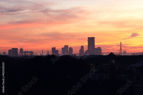 Orange morning sky sunrise over city skyscraper view, skyline horizon cityscape and urban architecture buildings at dawn