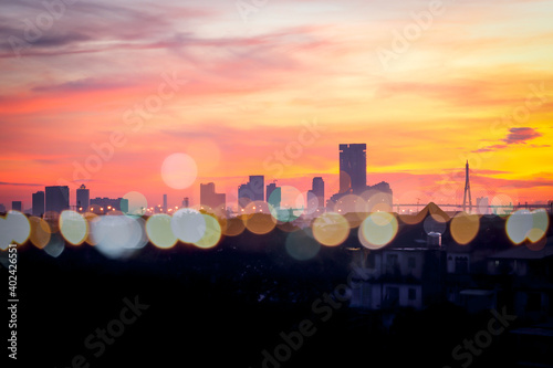 Orange morning sky sunrise over city skyscraper view with bokeh light, skyline horizon cityscape and urban architecture buildings at dawn