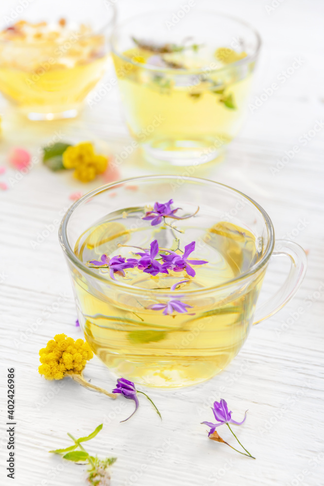 Cups with floral tea on light background