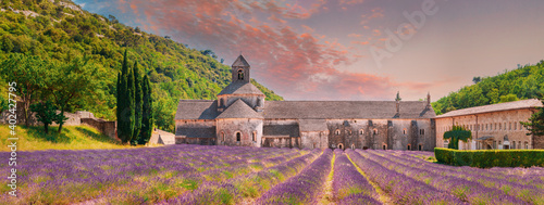 Notre-dame De Senanque Abbey, Vaucluse, France. Beautiful Landscape Lavender Field And An Ancient Monastery Abbaye Notre-dame De Senanque. Elevated View, Panorama. Altered Sunset Sky photo