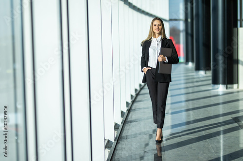 Portrait of successful businesswoman walking with laptop in an office. © F8  \ Suport Ukraine
