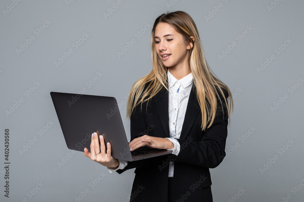 Successful business woman is standing with laptop on white isolated background. Successful business woman is standing with laptop on white isolated background.