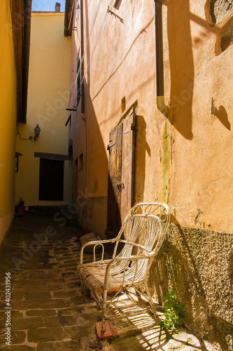An old chair outside a residential building in the historic medieval village of Scansano, Grosseto Province, Tuscany, Italy
