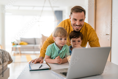 Happy family at home looking at laptop and having fun
