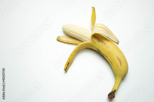 one ripe and open banana lies on a white background