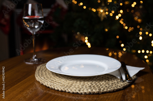 round jute napkin hand made against the background of a Christmas tree and fireplace. a glass of water dinner