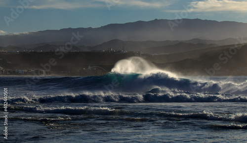 Powerful foamy ocean waves waves are breaking along Las Canteras and El Confital town beaches in Las Palmas de Gran Canaria 