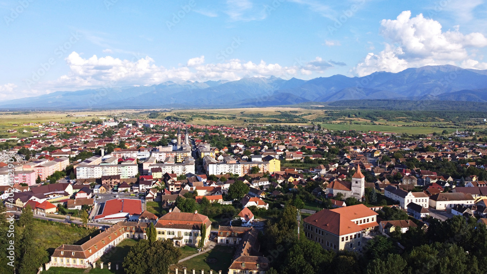 Drone panoramic view of small town in Transylvania, with the Carpathian mountains in the back
