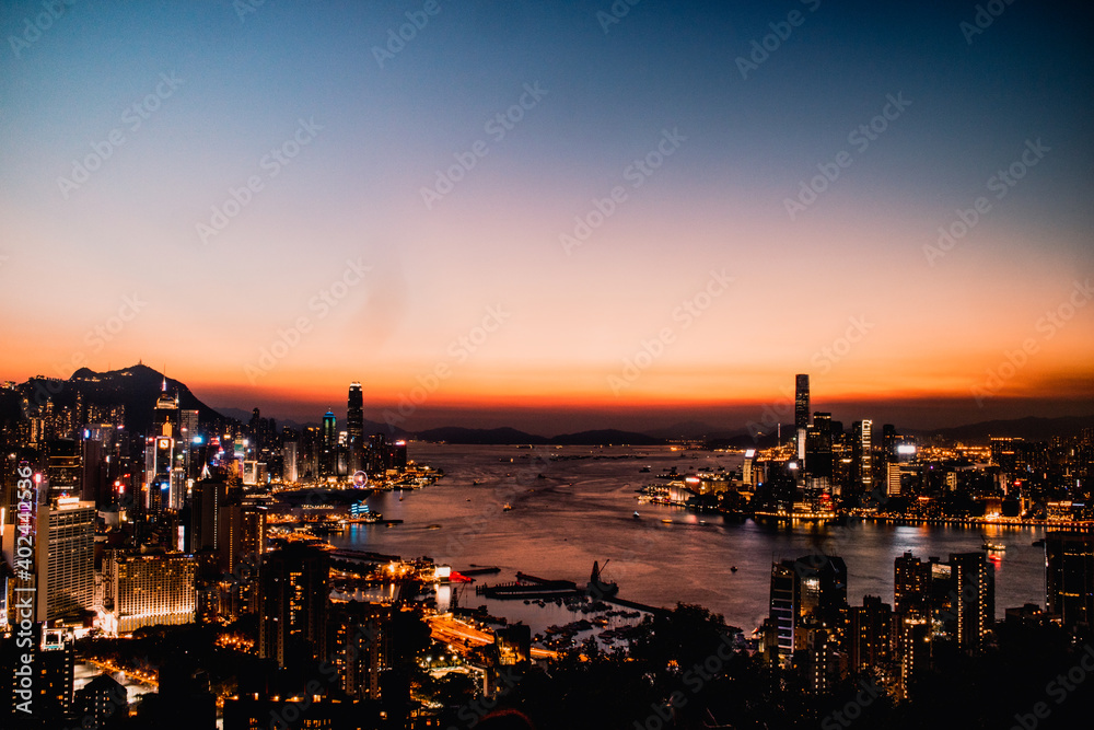 Obraz premium dos skyline de hong kong atardecer al fondo tonos azules y naranjas