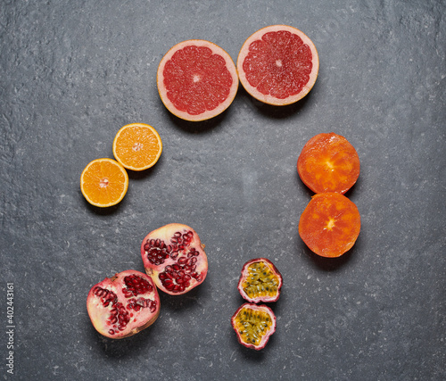 Pomegrade, orange, grapefruit, passion fruit and kaki on grey dark background
