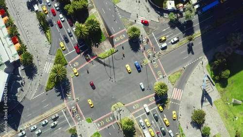 Aerial top down footage; turning around a large crossing with many cars and people in a busy street in the business district of Quito; the capital of Ecuador; South America