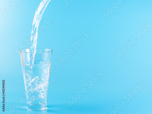 Glass with water aqua on blue background