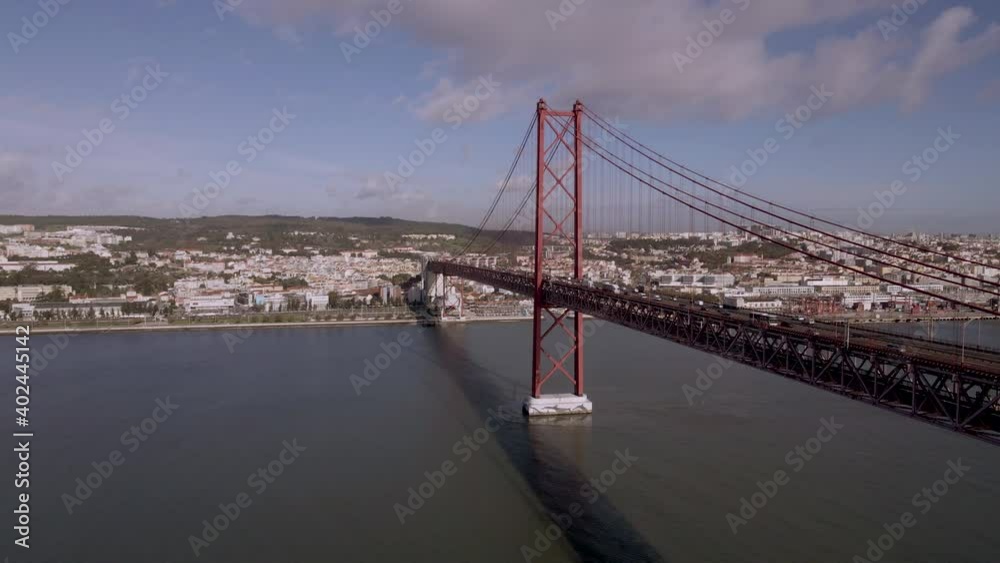 Beautiful aerial view of the 25th of April suspended bridge in Lisbon, Portugal. Amazing drone footage of the most famous Portuguese bridge at sunset with the Lisbon skyline in the background. Beautiful aerial view of the 25th of April suspended bridge in Lisbon, Portugal. Amazing drone footage of the most famous Portuguese bridge at sunset with the Lisbon skyline in the background.